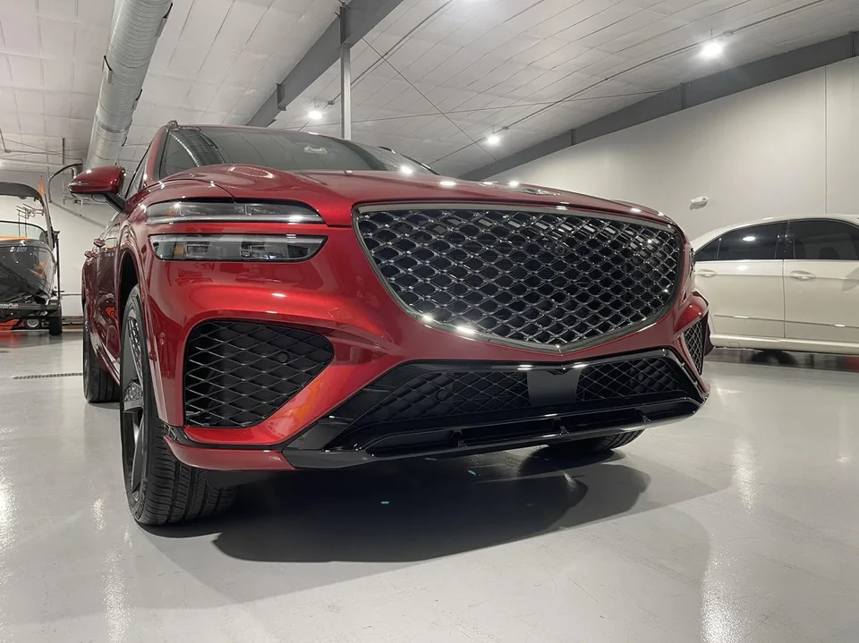 Red Genesis GV70, front view in the bright white shop bay